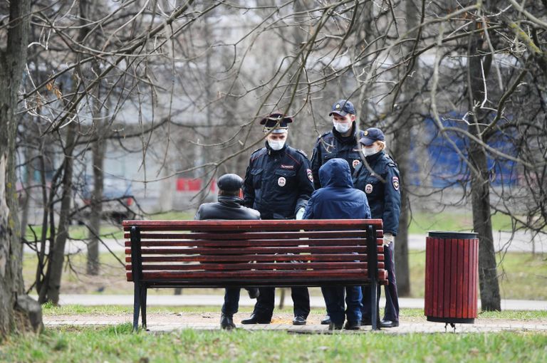 Сотрудники полиции разговаривают с людьми, сидящими на скамейке в сквере Сотрудники полиции разговаривают с людьми, сидящими на скамейке в сквере
