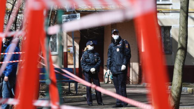 Сотрудники полиции недалеко от огороженной детской площадки в период самоизоляции жителей Сотрудники полиции недалеко от огороженной детской площадки в период самоизоляции жителей