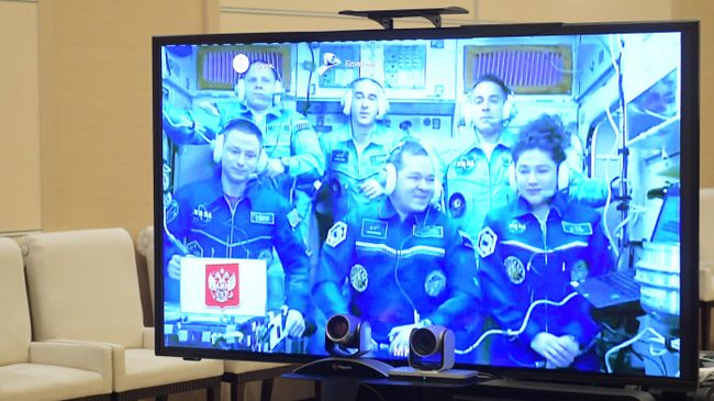 Экипаж Международной космической станции на экране во время сеанса связи с президентом РФ Владимиром Путиным 