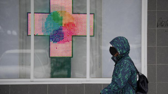 Прохожий в медицинской маске около аптеки в городе Щелково Московской области Прохожий в медицинской маске около аптеки в городе Щелково Московской области