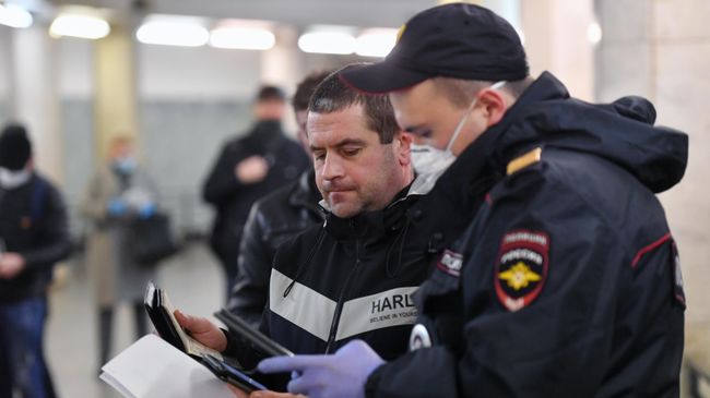 Пассажир метро показывает код своего электронного пропуска на экране смартфона сотруднику полиции на станции метро Сокольники в Москве