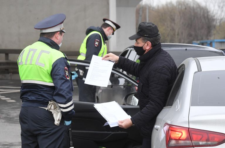 Сотрудники ГИБДД во время проверки электронных пропусков у водителей на блокпосту при въезде в Москву Сотрудники ГИБДД во время проверки электронных пропусков у водителей на блокпосту при въезде в Москву
