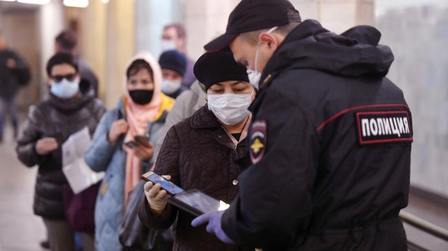 Пассажирка метро показывает код своего электронного пропуска на экране смартфона сотруднику полиции на станции метро Сокольники в Москве Пассажирка метро показывает код своего электронного пропуска на экране смартфона сотруднику полиции на станции метро Сокольники в Москве