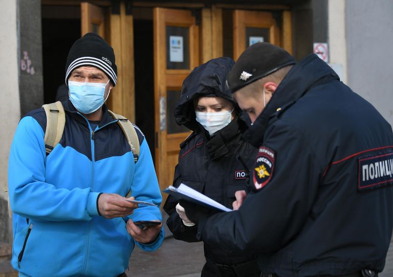 Сотрудники полиции проверяют цифровой пропуск у мужчины в Москве Сотрудники полиции проверяют цифровой пропуск у мужчины в Москве