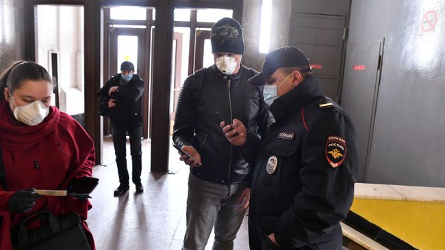 Пассажир метро показывает код своего электронного пропуска на экране смартфона сотруднику полиции на станции метро Сокольники в Москве Пассажир метро показывает код своего электронного пропуска на экране смартфона сотруднику полиции на станции метро Сокольники в Москве