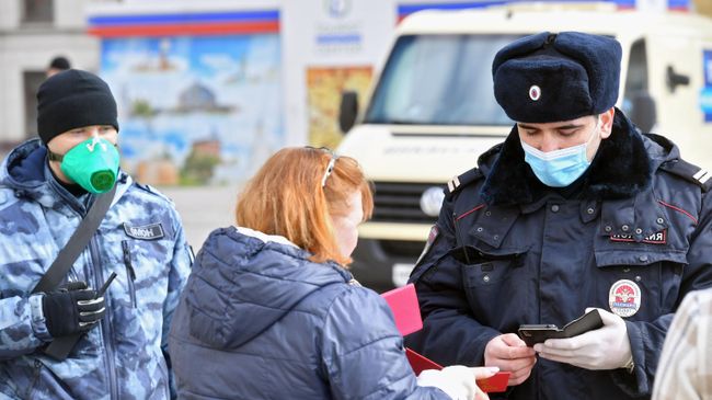 Сотрудник полиции проверяет документы у женщины в Москве Сотрудник полиции проверяет документы у женщины в Москве