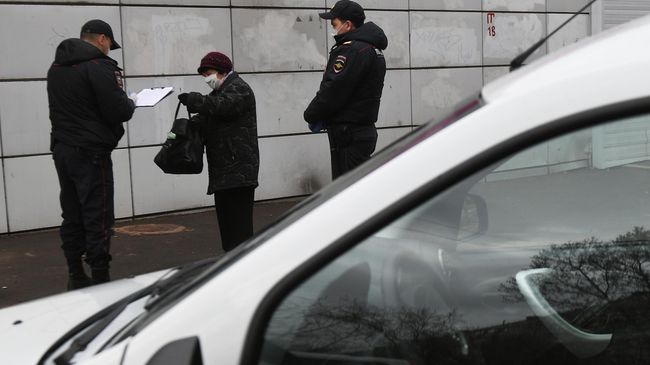 Сотрудники полиции разговаривают с прохожей