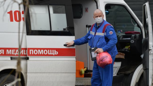 Медицинский работник у машины скорой помощи Медицинский работник у машины скорой помощи