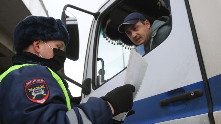 Инспектор дорожно-патрульной службы проверяет у водителя цифровой пропуск на передвижение по Москве Инспектор дорожно-патрульной службы проверяет у водителя цифровой пропуск на передвижение по Москве