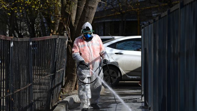Сотрудник коммунальной службы проводит дезинфекцию внутридворовой территории Сотрудник коммунальной службы проводит дезинфекцию внутридворовой территории