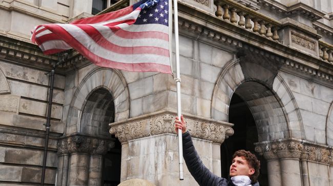 Участник акции с требованием отмены карантина в США на одной из улиц Олбани Участник акции с требованием отмены карантина в США на одной из улиц Олбани