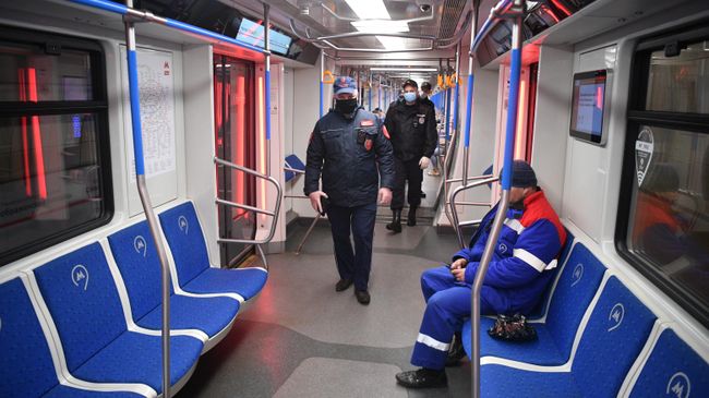 Сотрудники полиции в защитных масках в вагоне московского метро во время рейда по контролю за соблюдением социальной дистанции в 1,5 м Сотрудники полиции в защитных масках в вагоне московского метро во время рейда по контролю за соблюдением социальной дистанции в 1,5 м