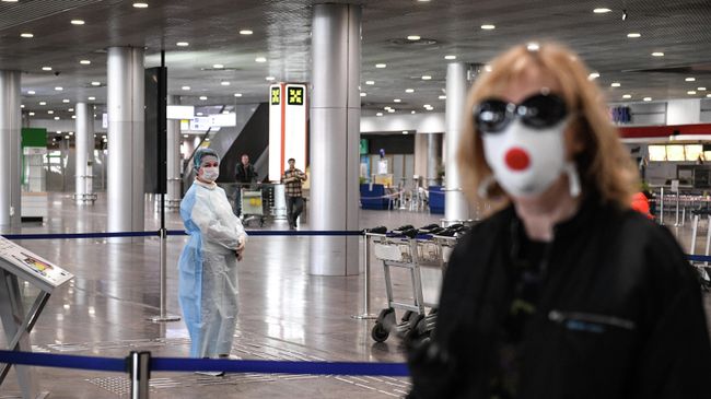 Сотрудница в защитном костюме в терминале F Международного аэропорта Шереметьево Сотрудница в защитном костюме в терминале F Международного аэропорта Шереметьево