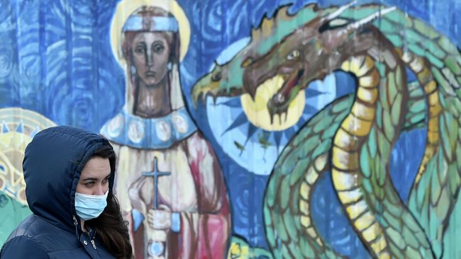 Женщина проходит мимо граффити в Киеве Женщина проходит мимо граффити в Киеве
