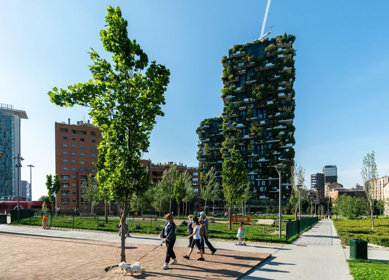 Отдыхающие в парке возле жилого комплекса Bosco Verticale в Милане Отдыхающие в парке возле жилого комплекса Bosco Verticale в Милане
