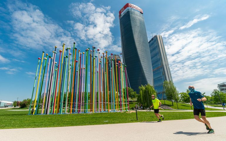 Мужчины совершают пробежку у небоскреба Generali Tower в Милане Мужчины совершают пробежку у небоскреба Generali Tower в Милане