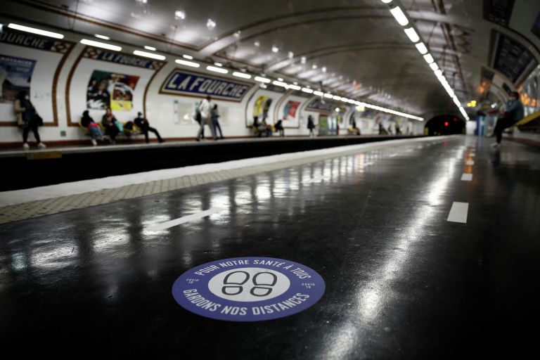 Стикер с призывом соблюдать дистанцию на одной из станций метро в Париже 