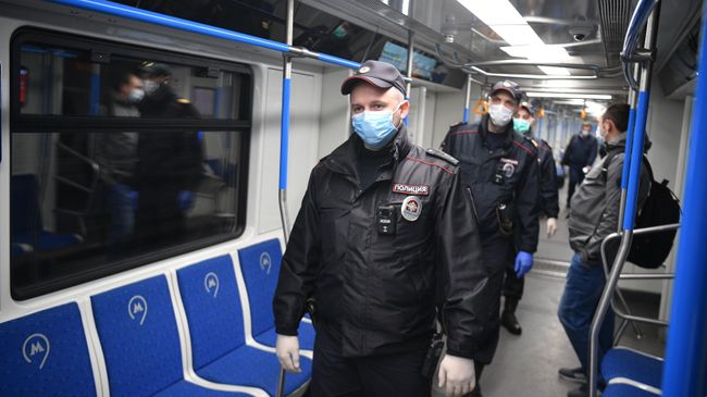 Сотрудники полиции в защитных масках в вагоне московского метро Сотрудники полиции в защитных масках в вагоне московского метро