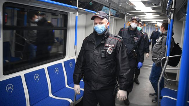 Сотрудники полиции в защитных масках в вагоне московского метро Сотрудники полиции в защитных масках в вагоне московского метро