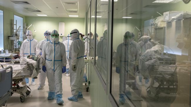 Врачи в отделении реанимации и интенсивной терапии госпиталя для зараженных коронавирусной инфекцией COVID-19 Врачи в отделении реанимации и интенсивной терапии госпиталя для зараженных коронавирусной инфекцией COVID-19