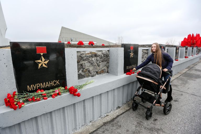 Девушка возлагает цветы к обелиску Города-герои в Мурманске Девушка возлагает цветы к обелиску Города-герои в Мурманске