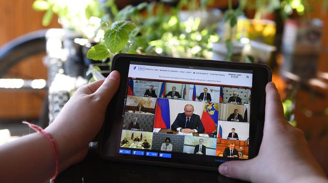 Женщина смотрит трансляцию совещания президента РФ Владимира Путина по ситуации, связанной с распространением коронавируса Женщина смотрит трансляцию совещания президента РФ Владимира Путина по ситуации, связанной с распространением коронавируса