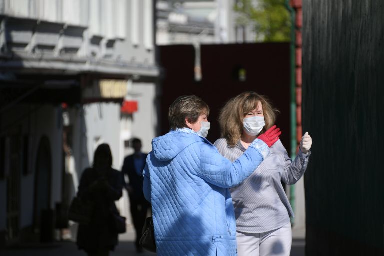 Женщины в медицинских масках и перчатках на одной из улиц в Москве Женщины в медицинских масках и перчатках на одной из улиц в Москве