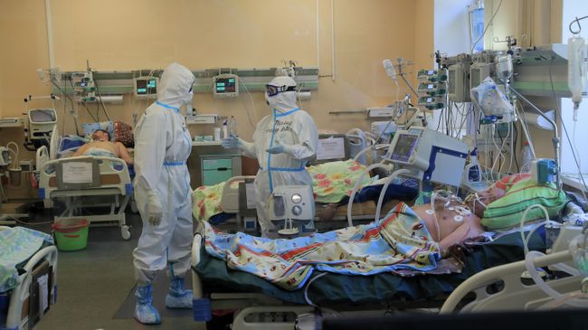 Медицинские работники в палате стационара для больных с коронавирусной инфекцией Медицинские работники в палате стационара для больных с коронавирусной инфекцией