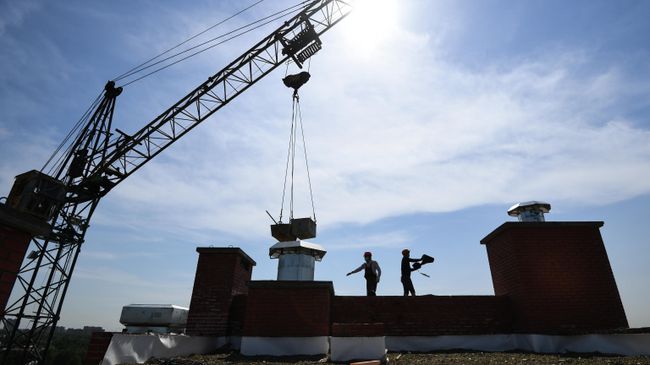 Рабочие на строительной площадке жилого комплекса Рабочие на строительной площадке жилого комплекса