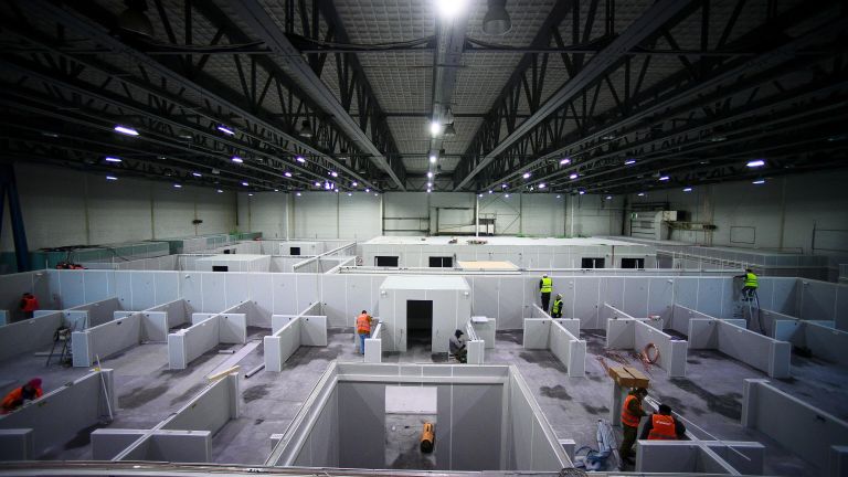Рабочие строят временный госпиталь для пациентов с COVID-19 на территории выставочного центра Сокольники в Москве Рабочие строят временный госпиталь для пациентов с COVID-19 на территории выставочного центра Сокольники в Москве