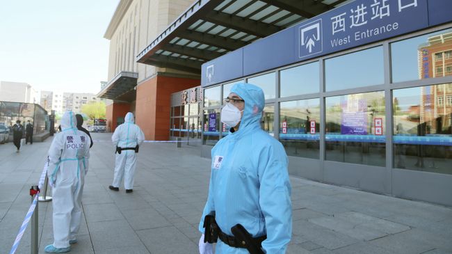 Сотрудники полиции в защитных костюмах на закрытой железнодорожной станции в провинции Цзилинь, Китай Сотрудники полиции в защитных костюмах на закрытой железнодорожной станции в провинции Цзилинь, Китай