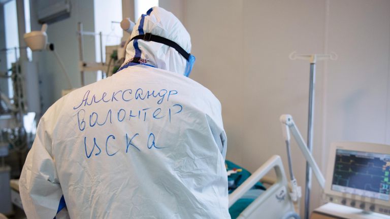 Волонтер возле кровати пациента в отделении реанимации и интенсивной терапии госпиталя COVID-19 в ГКБ No1 имени Н.И. Пирогова в Москве