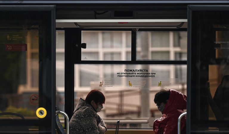 Пассажиры в защитных масках в салоне трамвая во время режима самоизоляции жителей Пассажиры в защитных масках в салоне трамвая во время режима самоизоляции жителей