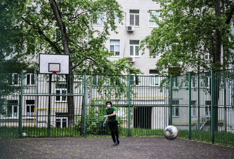 Подросток в защитной маске на спортивной площадке в одном из московских дворов во время режима самоизоляции жителей Подросток в защитной маске на спортивной площадке в одном из московских дворов во время режима самоизоляции жителей
