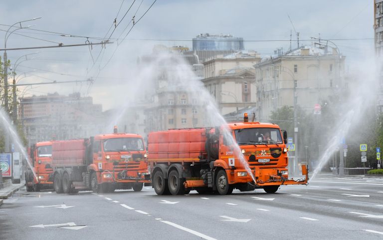 Автомобили коммунальных служб во время дезинфекции проезжей части дорог в Москве Автомобили коммунальных служб во время дезинфекции проезжей части дорог в Москве