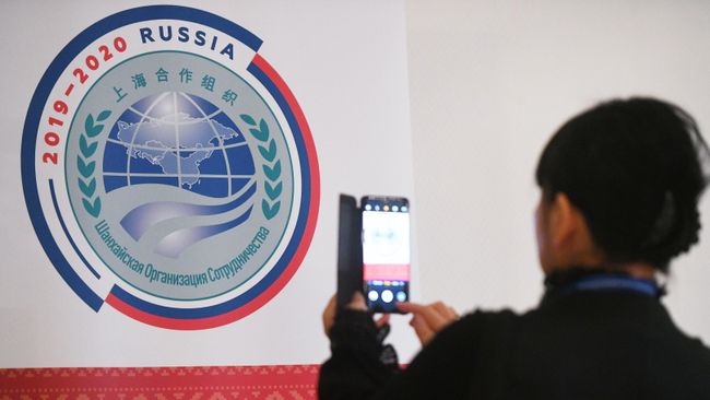 Участница совещания руководителей министерств и ведомств науки и техники государств-членов ШОС фотографирует логотип председательства России в ШОС Участница совещания руководителей министерств и ведомств науки и техники государств-членов ШОС фотографирует логотип председательства России в ШОС