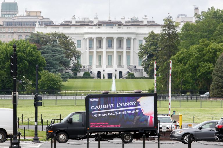 Рекламный щит с изображением президента США Дональда Трампа перед Белым домом Рекламный щит с изображением президента США Дональда Трампа перед Белым домом