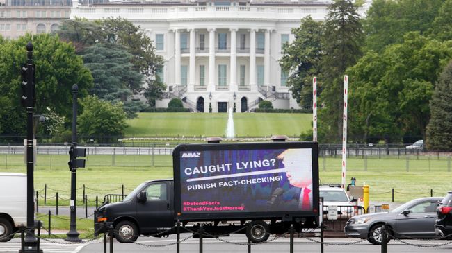 Рекламный щит с изображением президента США Дональда Трампа перед Белым домом Рекламный щит с изображением президента США Дональда Трампа перед Белым домом