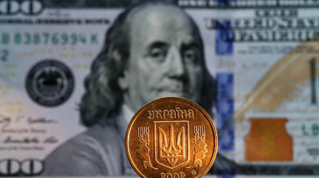 Денежная купюра долларов США и монета гривны Украины