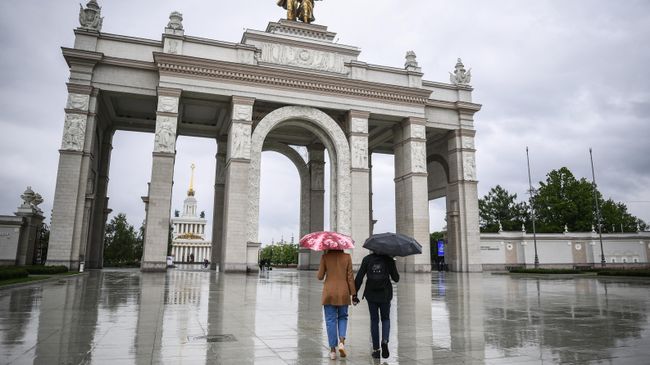 Прохожие у центрального входа на ВДНХ в Москве. ВДНХ вновь открылась для посещений в рамках второго этапа снятия ограничений в Москве, введенных для предотвращения распространения коронавируса Прохожие у центрального входа на ВДНХ в Москве. ВДНХ вновь открылась для посещений в рамках второго этапа снятия ограничений в Москве, введенных для предотвращения распространения коронавируса