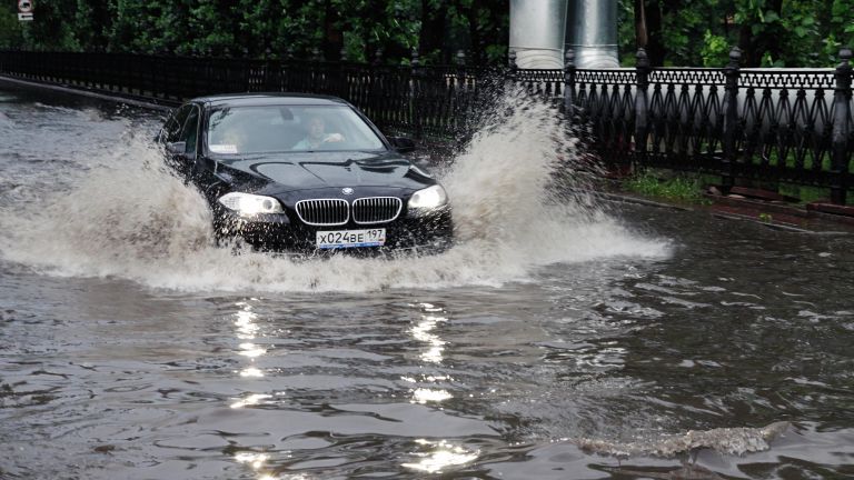 Автомобиль движется по Красногвардейскому бульвару после дождя в Москве Автомобиль движется по Красногвардейскому бульвару после дождя в Москве