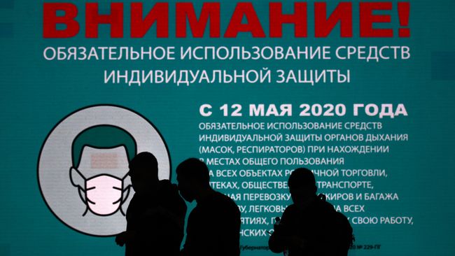 Люди около информационного баннера в аэропорту Шереметьево в Москве