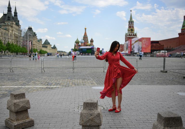Девушка фотографируется на Красной площади в Москве Девушка фотографируется на Красной площади в Москве