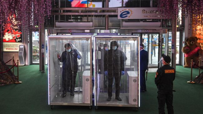 Посетители проходят через кабины дезинфекции при входе в торговый центр Европейский Посетители проходят через кабины дезинфекции при входе в торговый центр Европейский