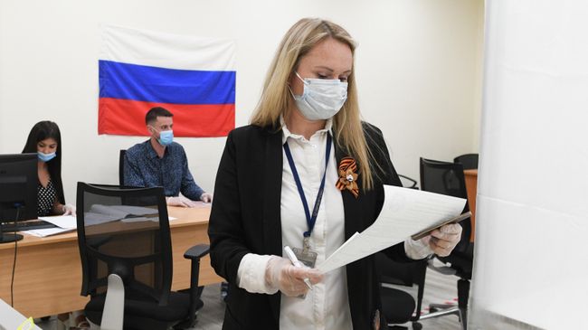 Женщина принимает участие в голосовании по внесению поправок в Конституцию РФ на избирательном участке Женщина принимает участие в голосовании по внесению поправок в Конституцию РФ на избирательном участке