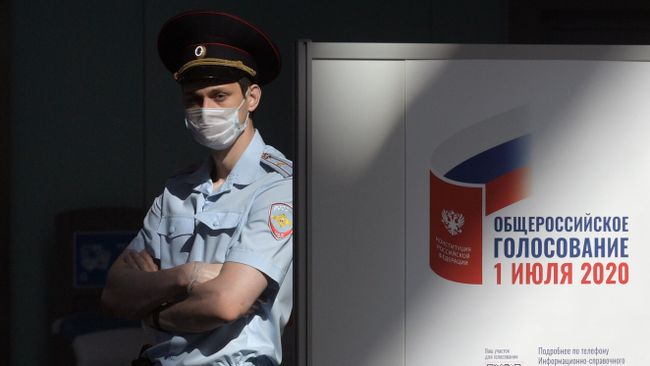 Полицейский на избирательном участке во время голосования по внесению поправок в Конституцию РФ Полицейский на избирательном участке во время голосования по внесению поправок в Конституцию РФ