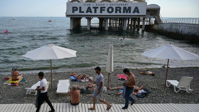 Отдыхающие на пляже Цирк в Сочи. На втором плане – ресторан-клуб Platforma Отдыхающие на пляже Цирк в Сочи. На втором плане – ресторан-клуб Platforma
