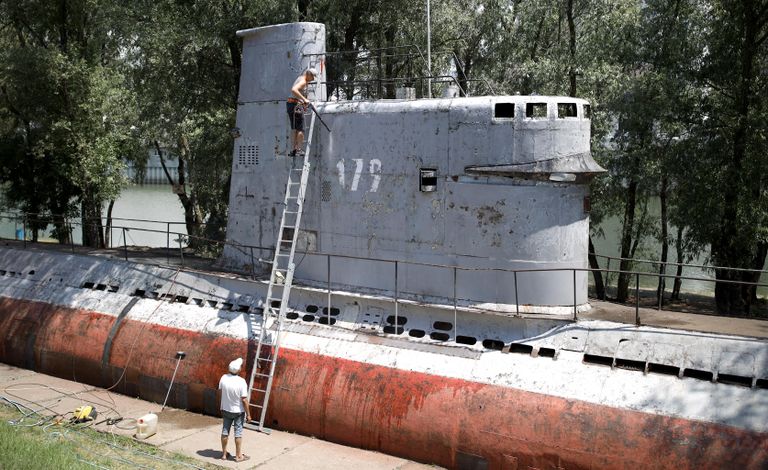 Местные жители чистят корпус малой многоцелевой дизельной подводной лодки М-261, установленной в парке 30-летия Победы в Краснодаре Местные жители чистят корпус малой многоцелевой дизельной подводной лодки М-261, установленной в парке 30-летия Победы в Краснодаре