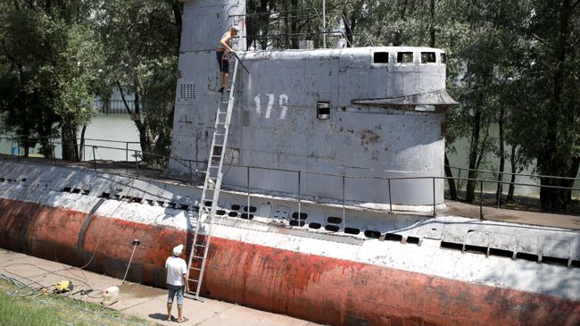 Местные жители чистят корпус малой многоцелевой дизельной подводной лодки М-261, установленной в парке 30-летия Победы в Краснодаре Местные жители чистят корпус малой многоцелевой дизельной подводной лодки М-261, установленной в парке 30-летия Победы в Краснодаре