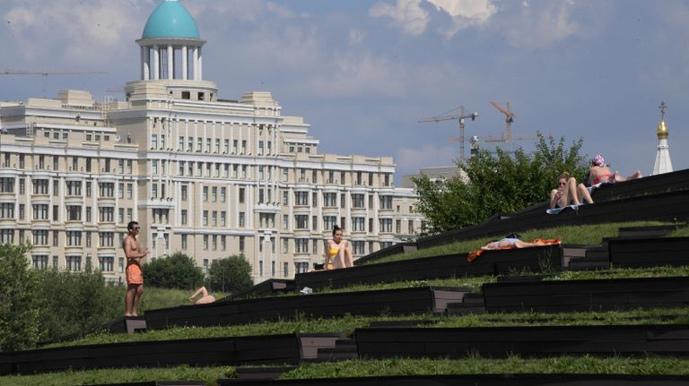 Отдыхающие загорают в парке Олимпийской деревни во время аномальной жары в Москве Отдыхающие загорают в парке Олимпийской деревни во время аномальной жары в Москве